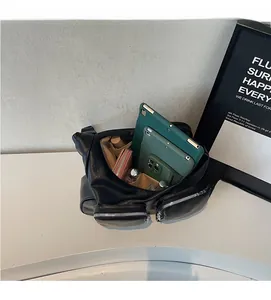 Top view of open black crossbody bag showing large capacity with various items