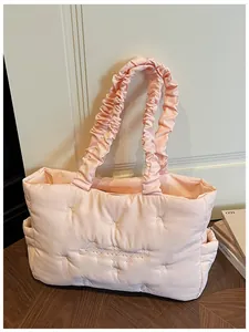 Detail of pink quilted nylon tote bag with floral embroidery and ruched handles