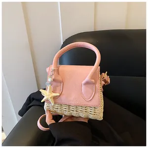 Detail of pink faux leather flap and beige straw woven body with starfish charm accessory
