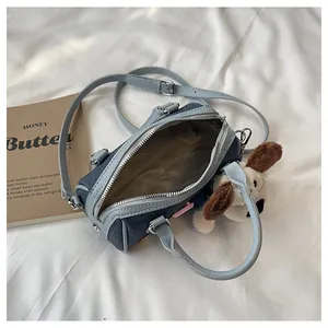 Close-up of the denim Boston bag interior with lining and cute plush puppy charm