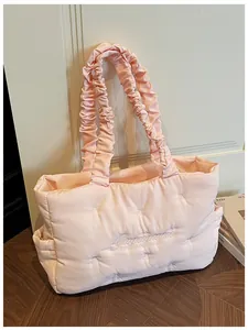 Detail of pink quilted tote bag with bow embroidery and ruffled scrunchie shoulder strap