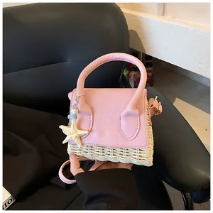 Close-up of mini straw bag with pink leather flap and starfish charm handheld detail