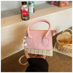 Detail of pink leather and straw mini bag with ocean shell charms for summer