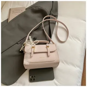 Detailed shot of pink PU mini bag with decorative pearls and white lace bow accessory