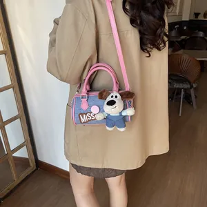 Blue denim Boston bag with pink trim, embroidered letters, and a cute puppy plush charm