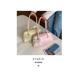 Détail de sacs à bandoulière en cuir PU rose et jaune avec perles cœur et nœuds ruban