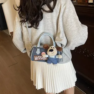 Blue denim Boston bag with cartoon puppy pendant and leather handles for women