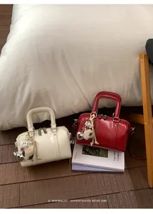 Detail of vintage cream and red pillow bags with glossy finish and decorative heart charms