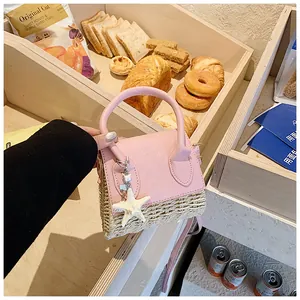 Detailed shot of pink leather and straw mini bag with starfish charm in a bakery setting