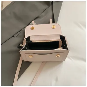 Detailed top view of open pink leather handbag with magnetic snap and interior zipper pocket