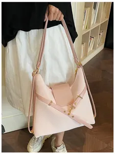 Detail van een roze hobo-tas van oliewasleer met belettering en goudkleurige hardware