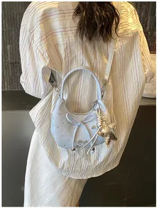 Detail van lichtblauwe handtas met sterrenpatroon, strik en ster-accessoire