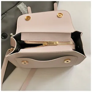 Detail view of pink square crossbody bag with magnetic snap and gold zipper interior