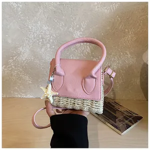 Detail of pink leather and straw mini bag with starfish charm and elegant top handle