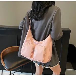 Detail of pink glossy hobo bag with double zipper pockets shown on a fashion model