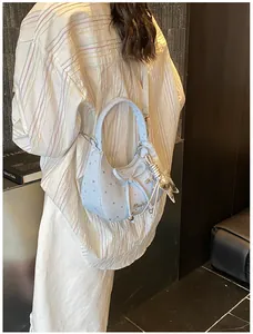 Detail van de lichtblauwe hobo-tas met stervormige patronen en een metalen sterhanger