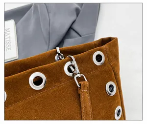 Detailed macro view of dark brown suede bag featuring silver metal eyelets and clasp