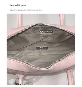 Vue intérieure du sac à main rose montrant le compartiment principal et la poche zippée