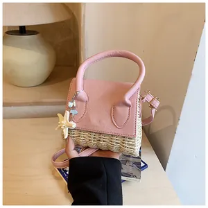 Detail of pink leather and woven straw mini bag with starfish charm and slim strap