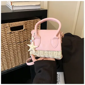 Detail of pink leather and straw mini bag featuring a starfish charm and top handle