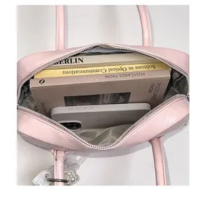 Vue intérieure du sac boston rose montrant un grand espace pour livres et téléphone
