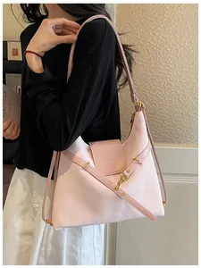 Detail van roze leren tote bag met gouden gesp en een elegant reliëflogo erop