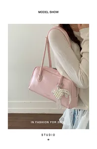 Détail du sac à bandoulière rose avec pendentif cœur perlé et nœud en dentelle chic