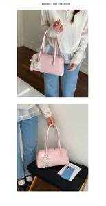 Vue détaillée du sac porté épaule rose avec breloque cœur perle et nœud en dentelle