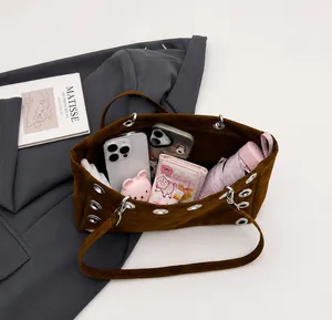 Overhead view showing the spacious interior of a brown suede shoulder bag with essentials