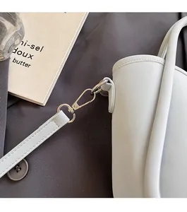 Macro detail of silver-tone metal hardware and stitching on a lychee pattern bucket bag