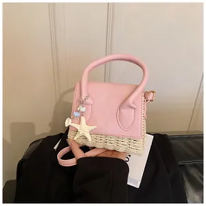 Close-up of pink straw mini bag with starfish charm and woven PU leather texture