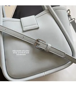 Detail of adjustable shoulder strap and lychee texture on light blue bucket bag