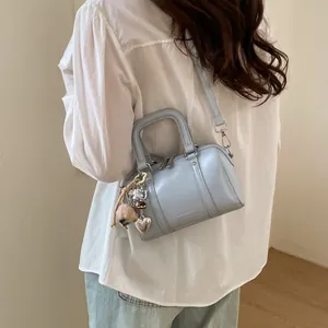 Light blue mini Boston bag with adjustable strap and decorative charm for daily wear