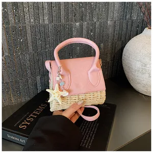 Pink leather and woven straw mini bag detail with a starfish charm and slim strap