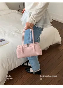 Détail du sac Boston en cuir PU brillant rose avec doubles poignées fines et fermeture éclair