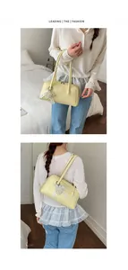 Détail du sac à bandoulière crème avec breloque cœur en perles et cuir synthétique