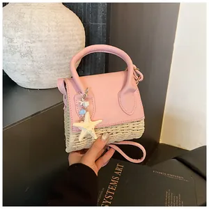 Close-up of pink leather and straw mini bag with starfish charm and round handle