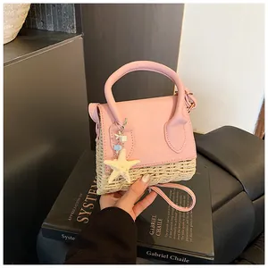 Detailed close-up of straw textured mini bag with pink flap and starfish charm