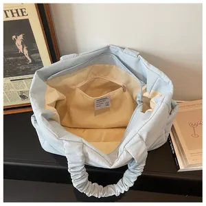 Interior view of quilted nylon tote bag with beige lining and a secure zipper pocket