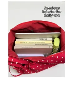 Spacious interior of red polka dot bag showing storage for books and tablet