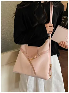 Roze gewaxte lederen draagtas op een model, met gouden gespen en een chic stedelijk design