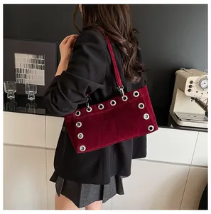 Detail view of burgundy velvet shoulder bag with silver eyelets and metal hardware