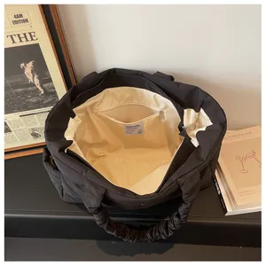 Interior view of black quilted nylon tote bag featuring a zip pocket and textile lining