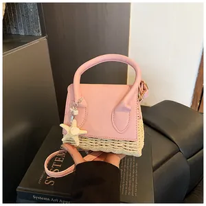 Detail of pink PU leather and woven straw mini bag with starfish charm accessory