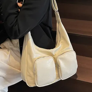 Chic cream white pleated shoulder bag with dual front pockets and adjustable wide strap