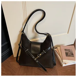 Detail van vintage donkerbruine leren shopper met zwarte band en gouden metalen beslag