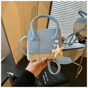 Detail of mini straw bucket bag featuring blue leather trim and ocean-themed charms