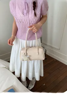 Détail du sac crème avec inscription Fashion & Bag et pendentif cœur en perles