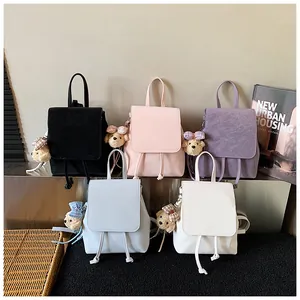 Close-up of five mini leather backpacks in pastel colors with cute bear charms