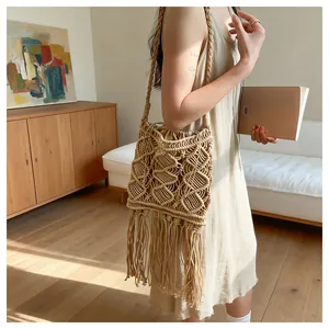 Detailed view of bohemian beige hand-woven shoulder bag with long flowing fringes